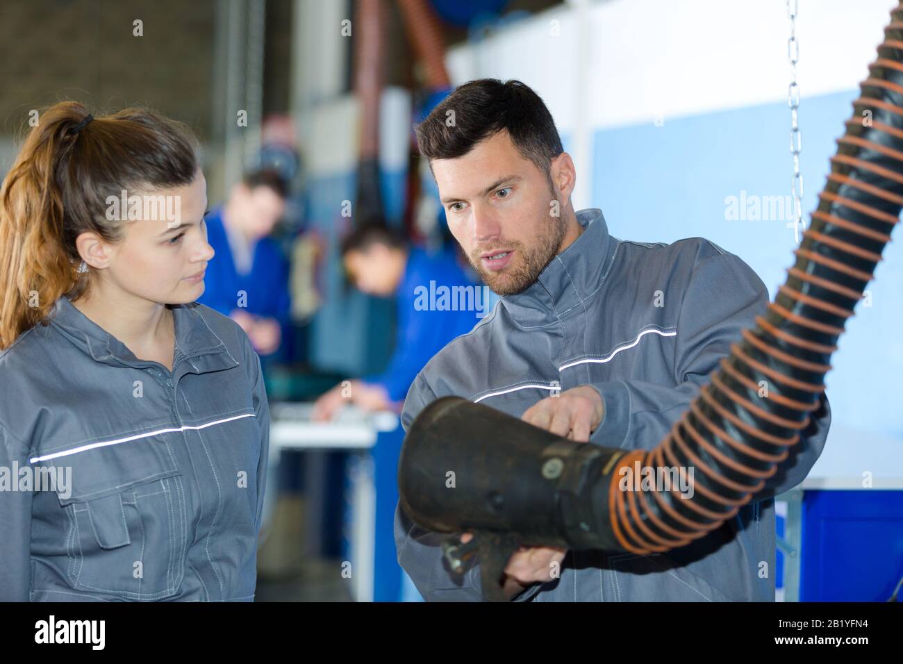 il meccanico che mostra l'estrattore per rimuovere i fumi Foto Stock