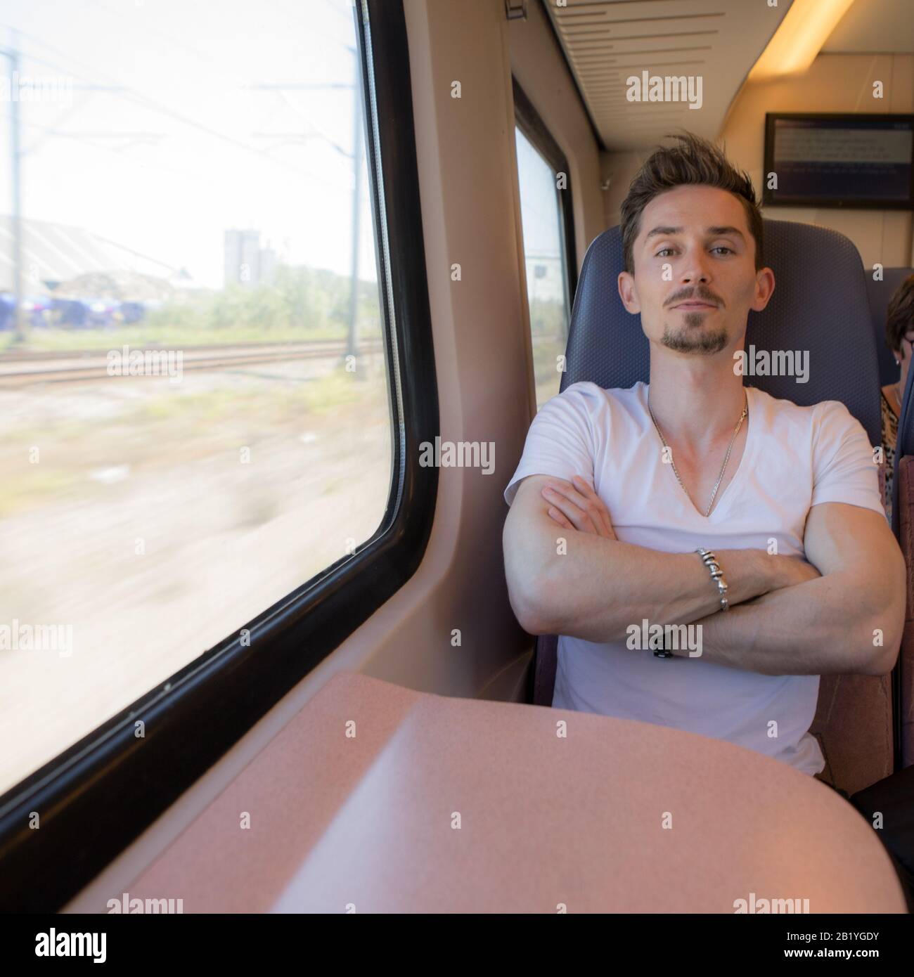 Giovane positivo bel uomo cavalcare un treno. Foto Stock