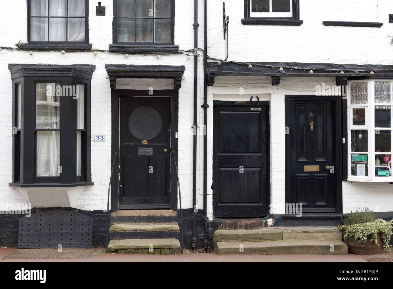 Porte anteriori in legno su Alloggi stile Tudor a Upton on Severn Foto Stock