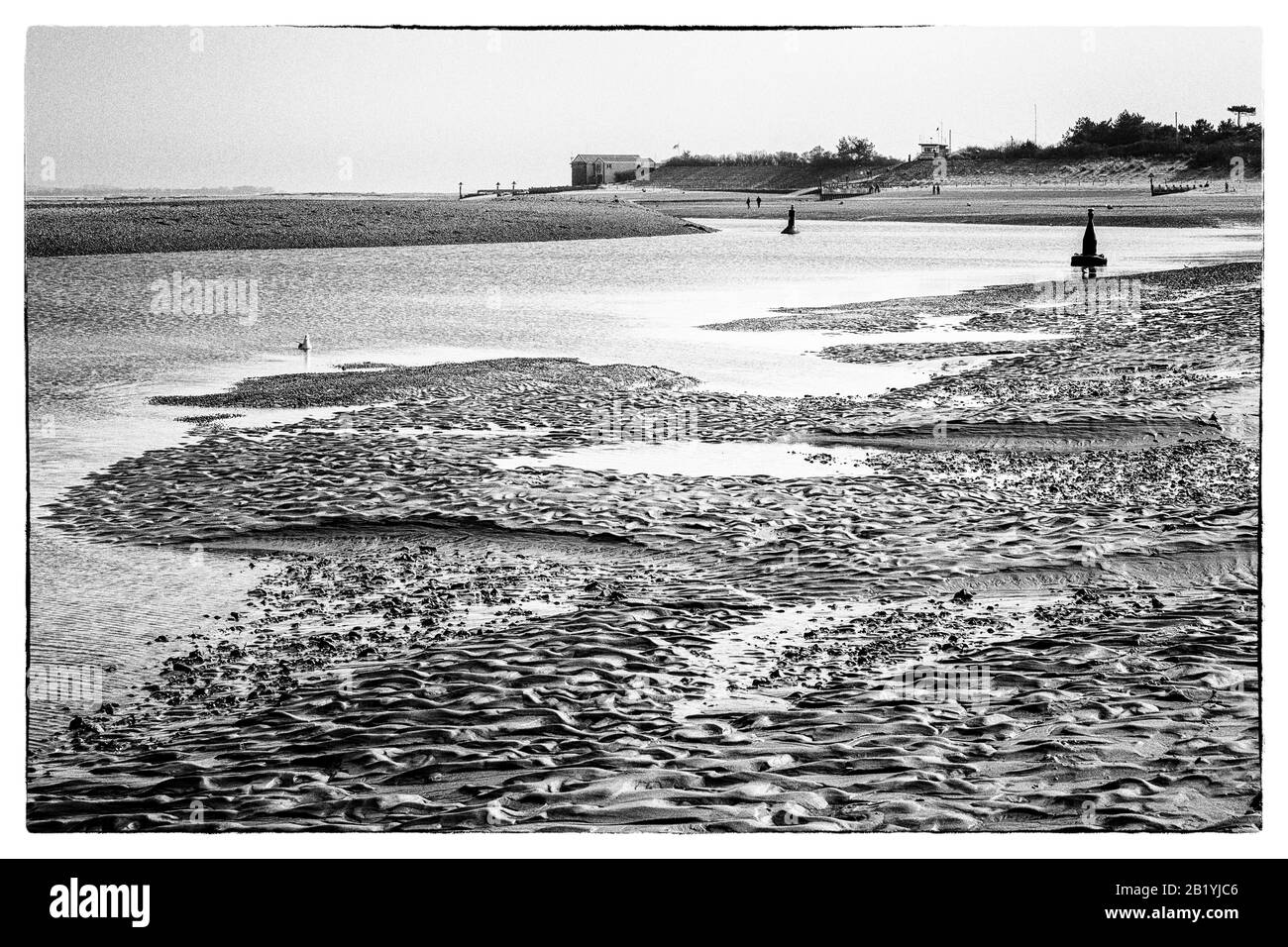 Pozzi spiaggia, con boe canale, bassa marea. Foto Stock