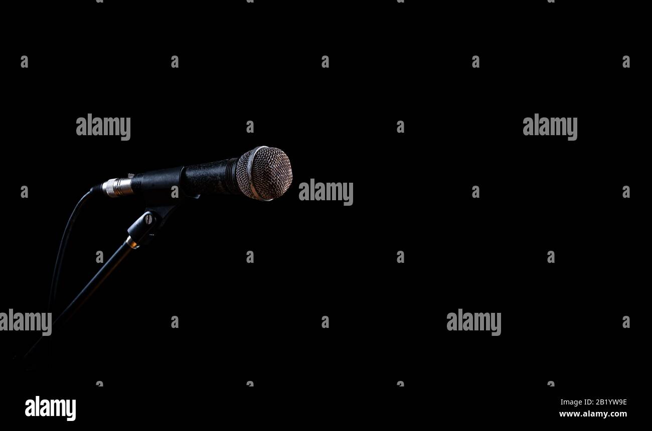 Vecchio microfono vintage isolato in camera oscura senza musicisti Foto Stock