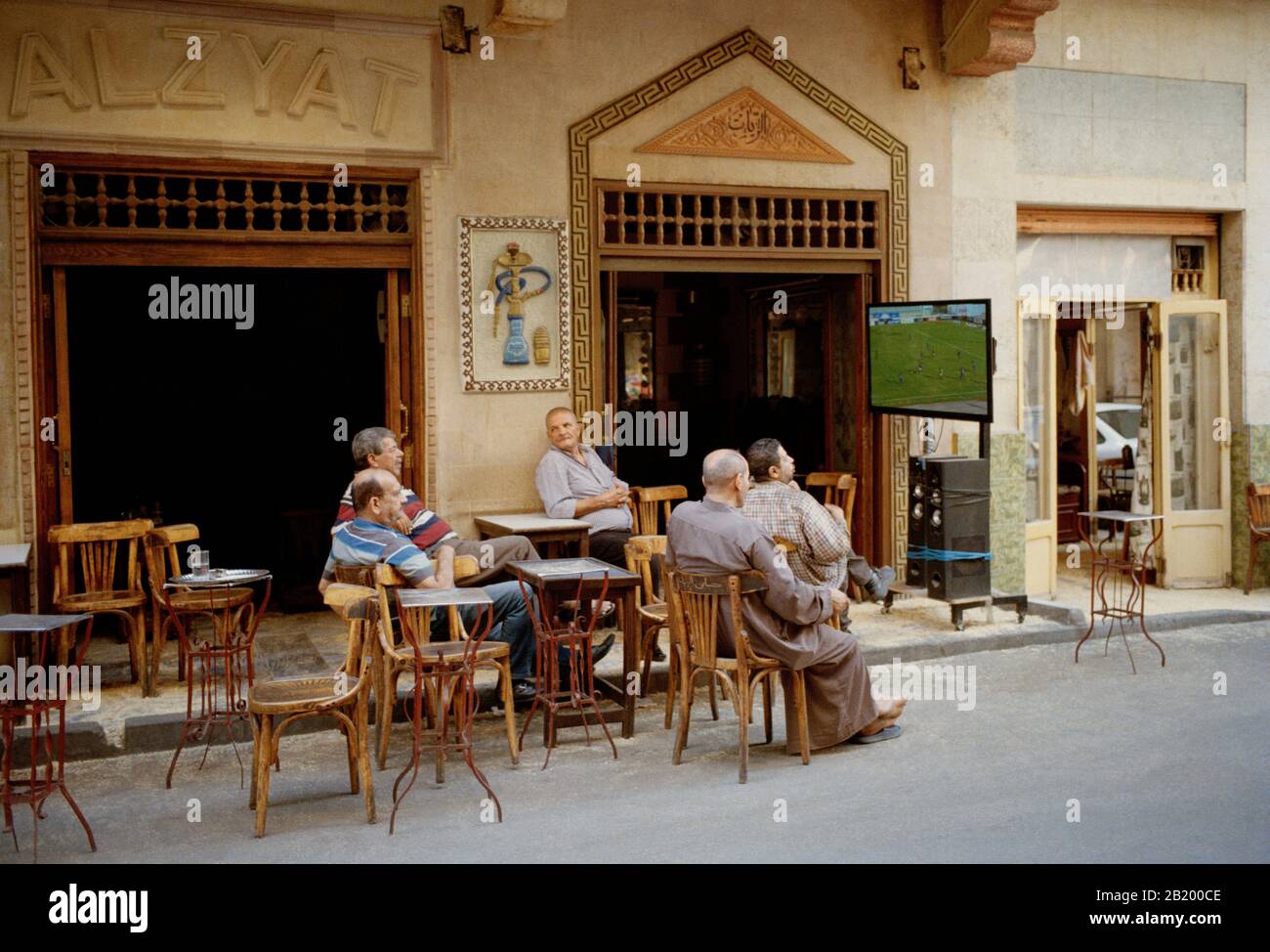 Uomini egiziani che guardano il calcio nelle strade del quartiere Tabbana nel quartiere islamico del Cairo della città del Cairo in Egitto in Nord Africa Foto Stock