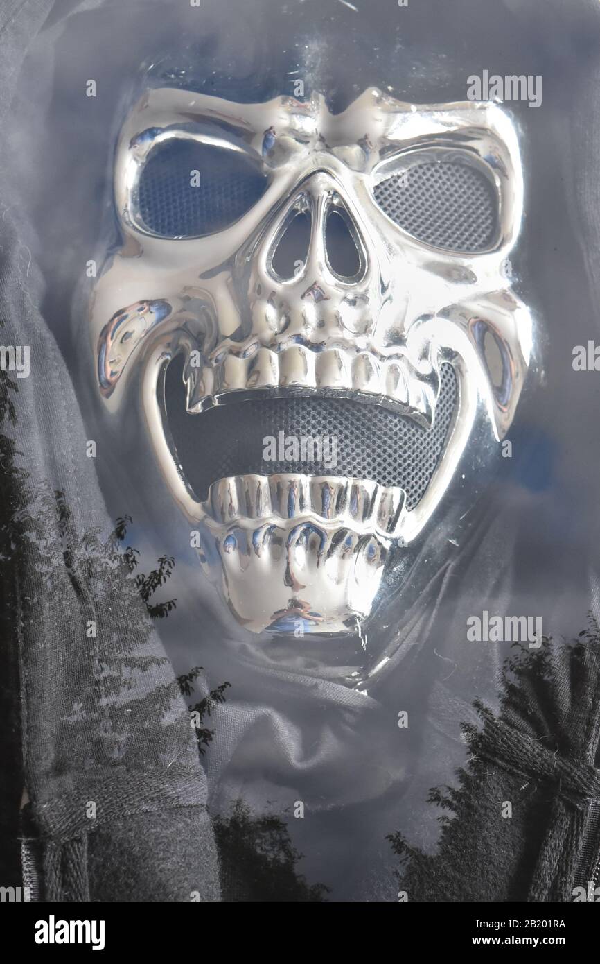 Maschera cranica testa di morte doppia esposizione contro un cielo nuvoloso Foto Stock