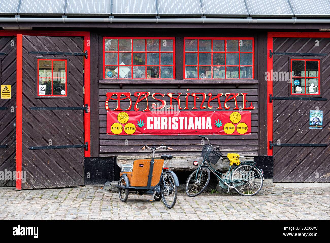 Edificio Maskinhal con tetto di pannelli solari a Freetown Christiania, una comunità hippie e comune istituito da squatters a Copenaghen, Danimarca Foto Stock