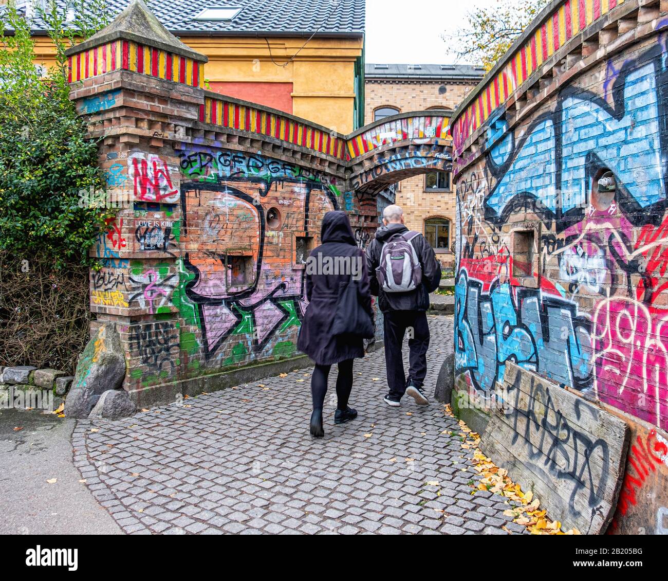 Colorato muro di mattoni ricoperto di graffiti all'ingresso di Freetown Christiania, Christianshavn, Copenhagen, Danimarca Foto Stock