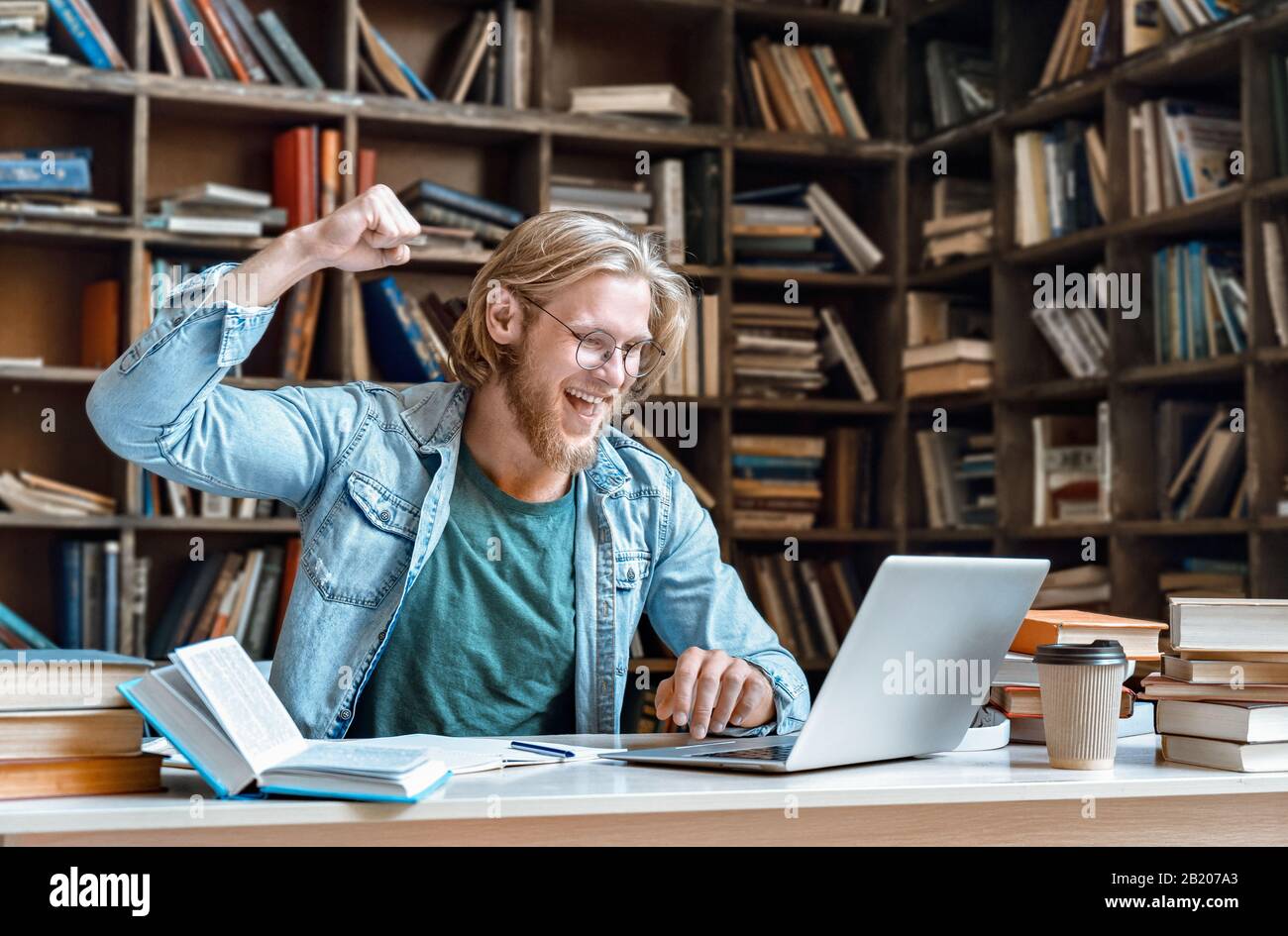 Il moderno portatile uomo eccitato grida hooray yeah prima vittoria gesto copia spazio. Foto Stock