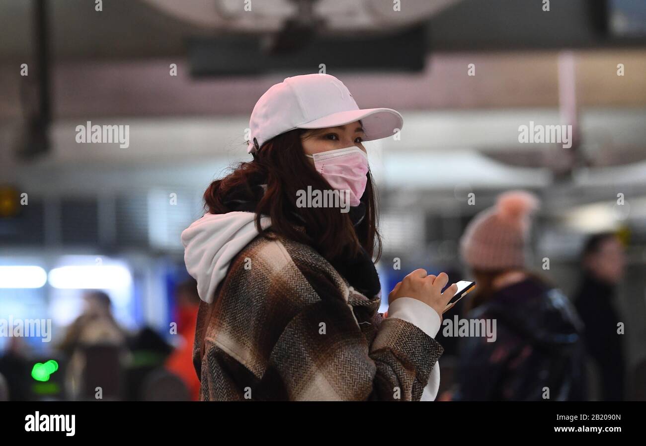 Una donna che indossa un facemask nella stazione della metropolitana di Westminster nel centro di Londra, come il primo caso di coronavirus è stato confermato in Galles e altri due sono stati identificati in Inghilterra - portando il numero totale nel Regno Unito a 19. Foto Stock