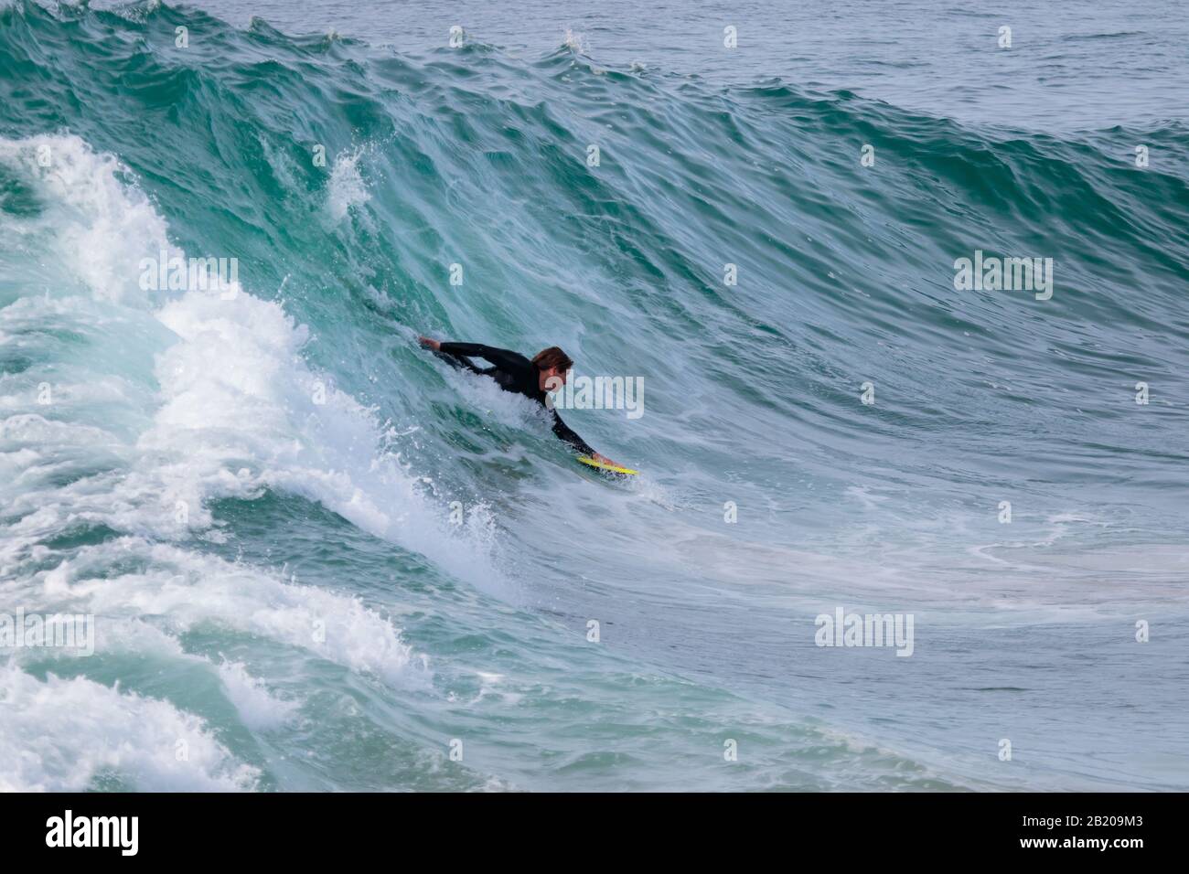 Surfista con un'onda di equitazione con una lavagna Foto Stock
