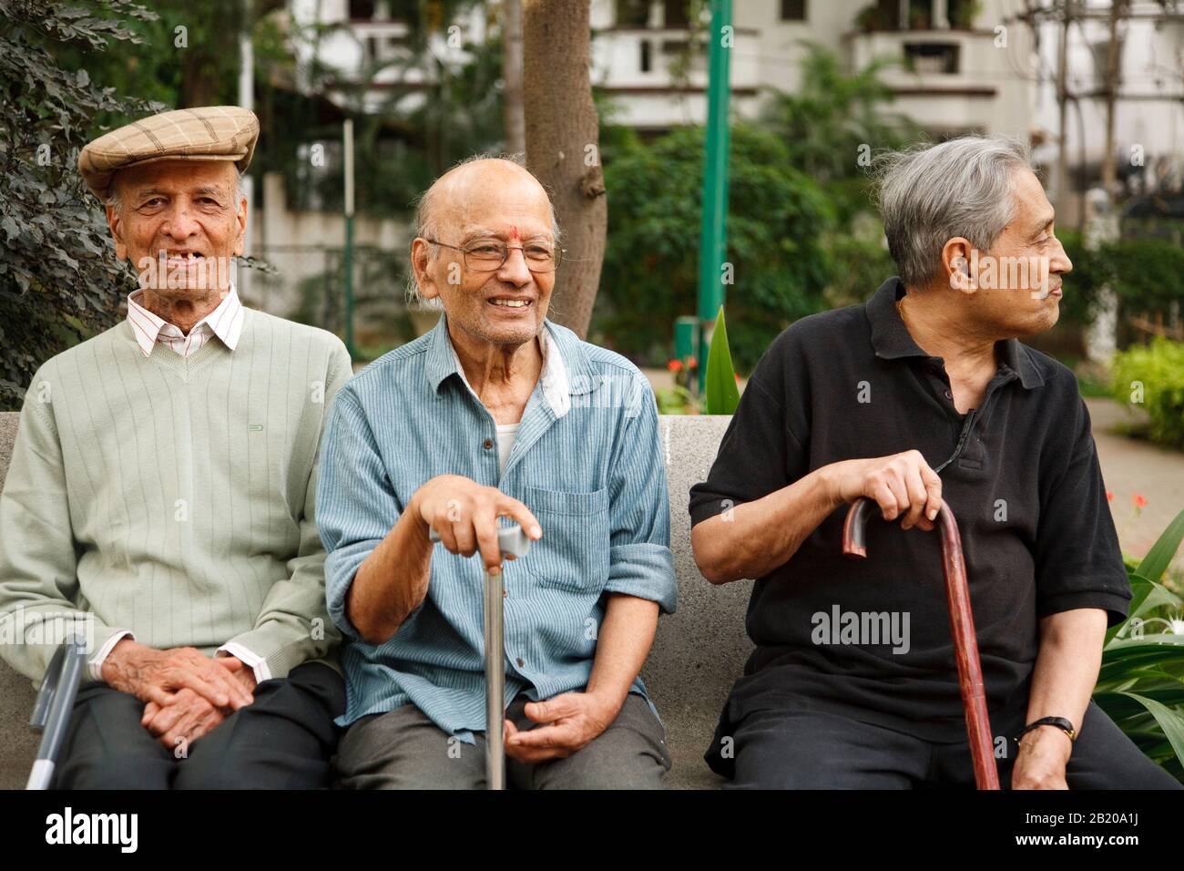 Bengaluru, INDIA - 25 giugno 2010. Gli uomini indiani vecchi felici si rilassano su una panchina del parco a Bangalore, India Foto Stock