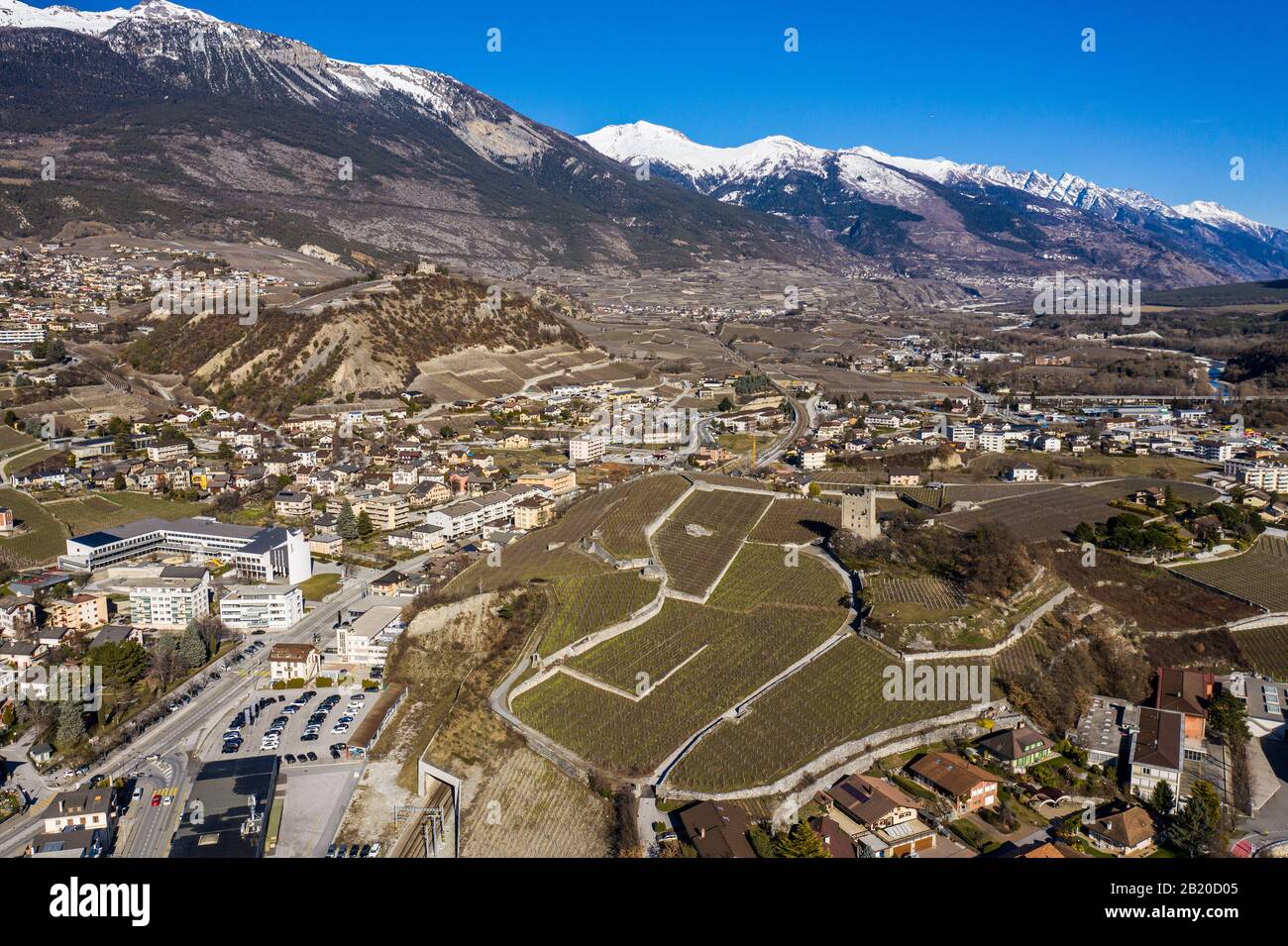 Veduta aerea della città di Sierre nel Canton Vallese con vigneti, e un castello e torre medievale che domina la valle del Rodano in Svizzera al sole Foto Stock