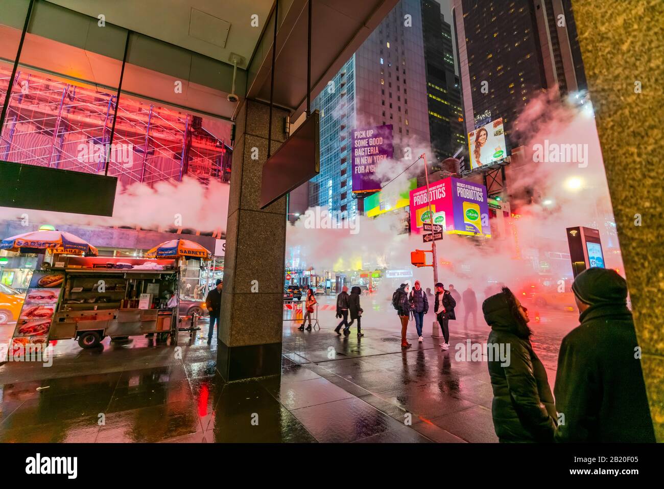 Il vapore che deriva circonda la gente, il traffico e gli edifici Di Times Square nella notte innevata al centro di Manhattan New York City NY USA il Gennaio 2020. Foto Stock