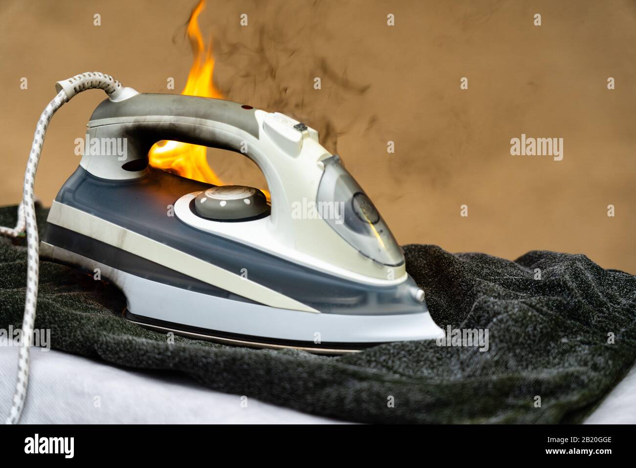 Si sono dimenticati di spegnere il ferro da stiro per la stiratura di panni. Una manipolazione impropria di elettrodomestici può causare un incendio. La casa starte Foto Stock