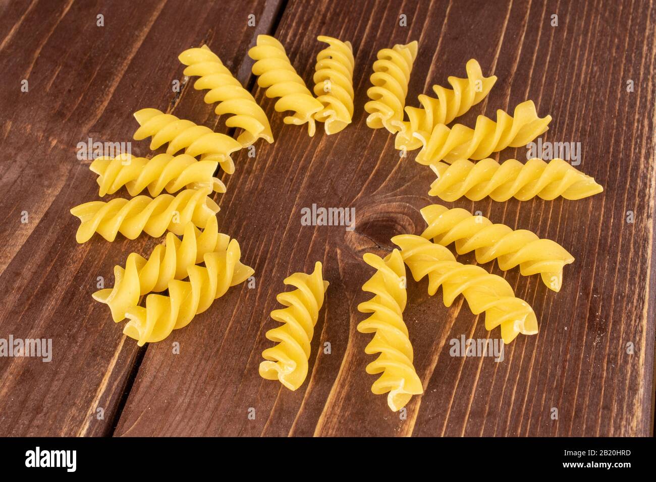 Lotto di pasta gialla intera fusilli cerchio su legno marrone Foto Stock