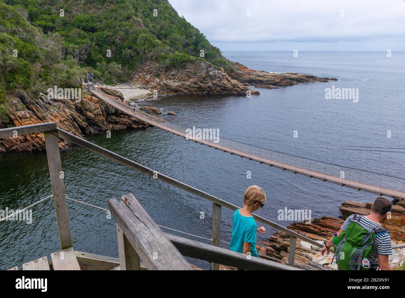 Padre e figlio in escursione attraverso il magnifico paesaggio A Tempeste River Mouth, Tsitsikamma National Park, Garden Route, vicino a Port Elizabeth, Sud Africa Foto Stock