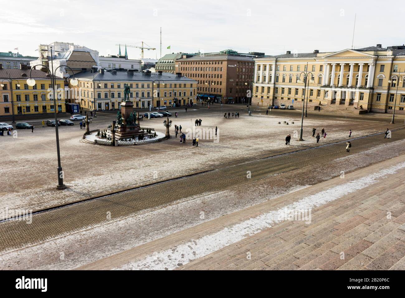 Helsinki, Finlandia. Piazza del Senato (Senaatintori), piazza pubblica con edifici neoclassici in una fredda giornata invernale, coperta di ghiaccio e neve Foto Stock