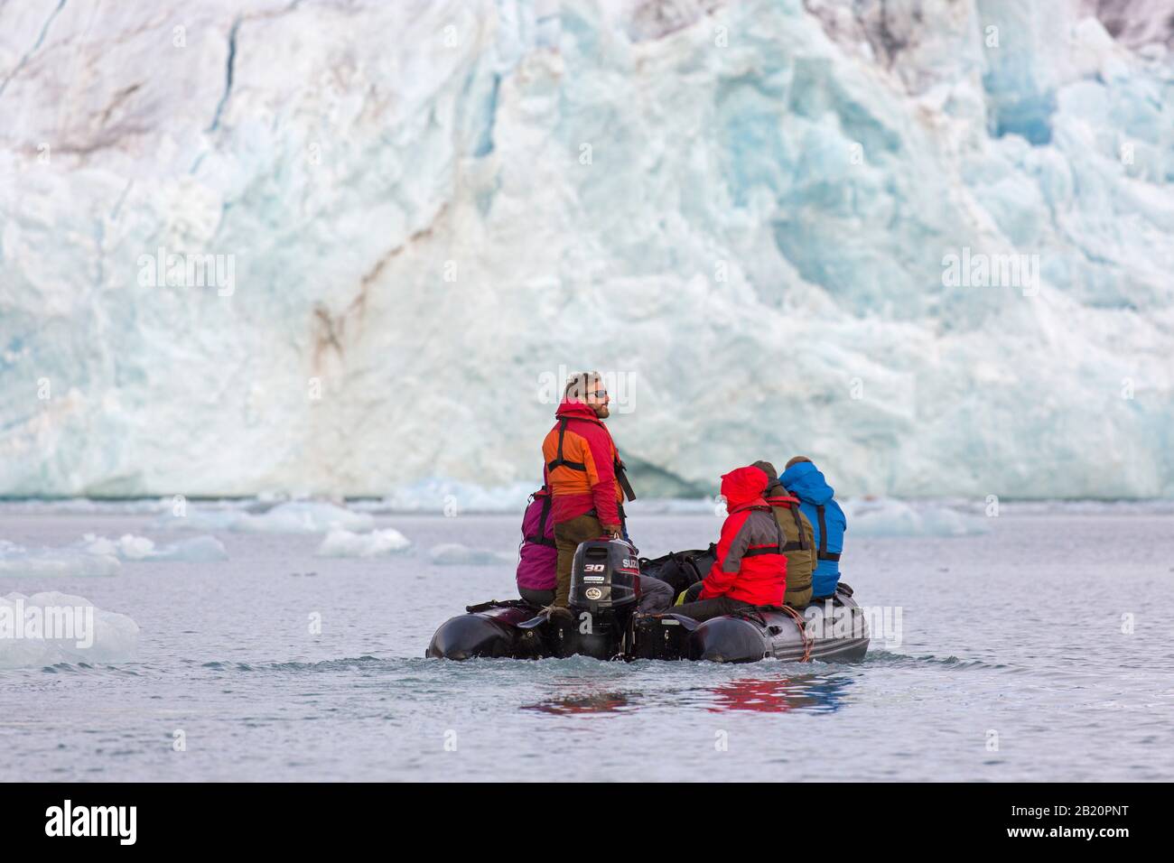 Eco-turisti che guardano Fjortende Julibreen / 14th di luglio Glacier che si calve in Krossfjorden, Haakon VII Land, Spitsbergen / Svalbard, Norvegia Foto Stock