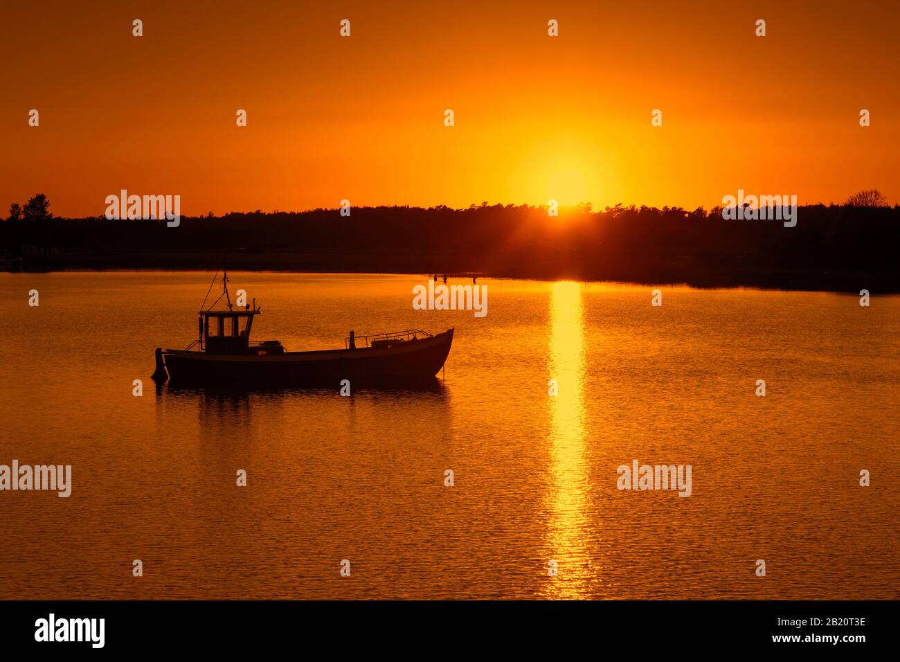 Imbarcazione da pesca silhouette contro il tramonto, isola di Ummanz, comune nel distretto di Vorpommern-Rügen nel Mecklenburg-Vorpommern, Germania Foto Stock
