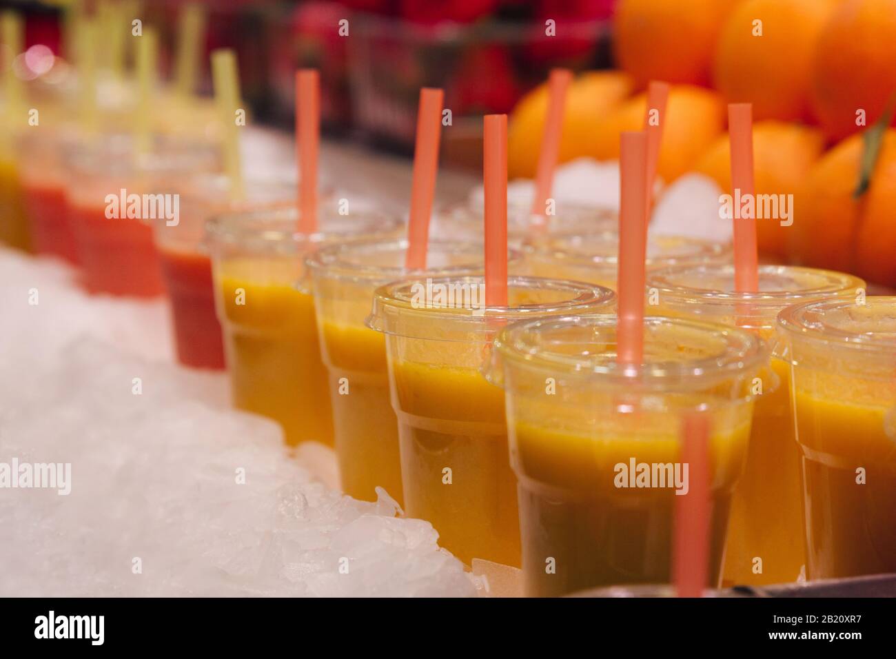 Foto di un gruppo di tazze di plastica con succhi di frutta freschi pronti per il consumo. Messa a fuoco selettiva Foto Stock