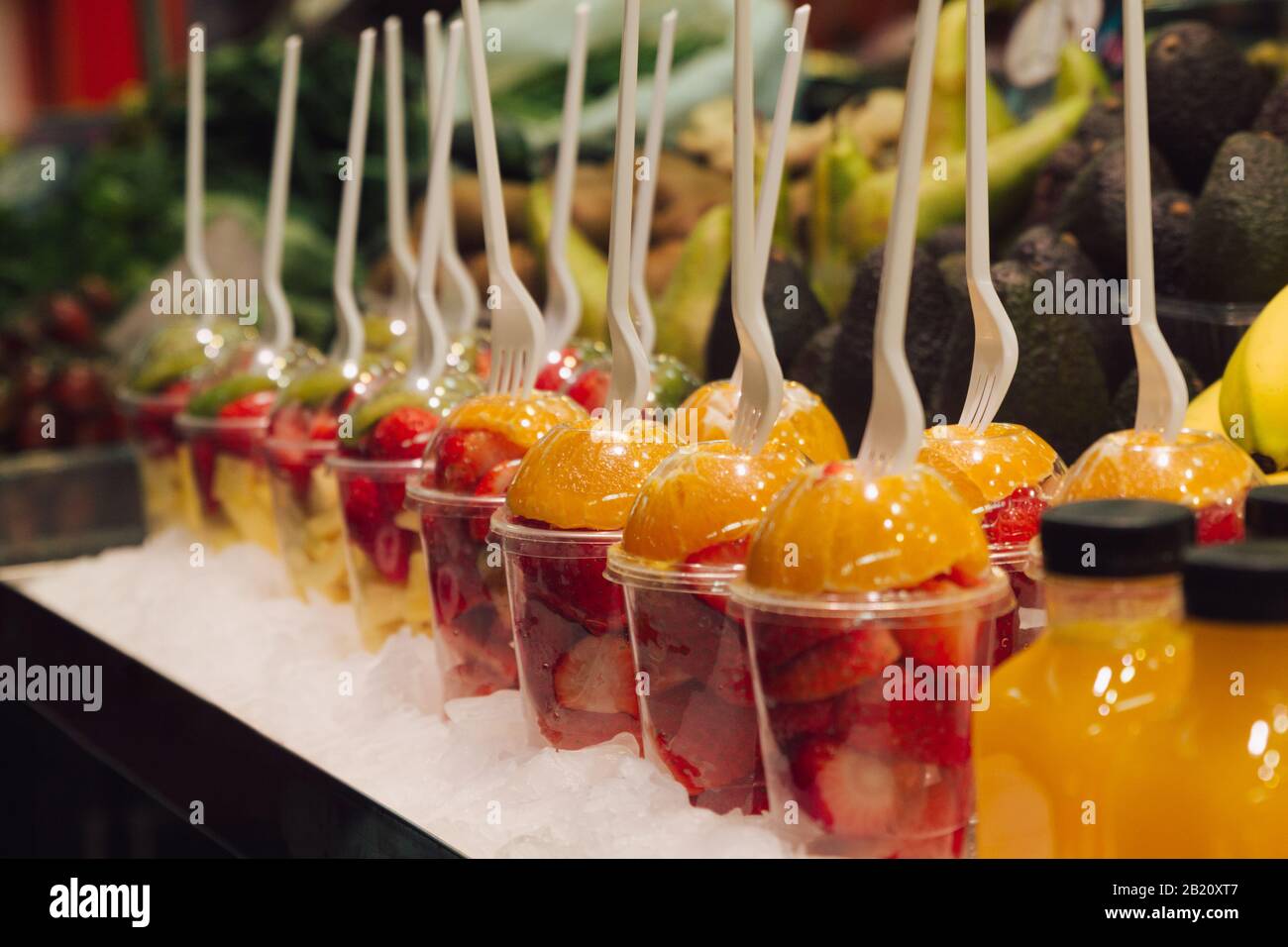 Foto di un gruppo di tazze di plastica con pezzi di deliziosa frutta fresca pronti per mangiare. Messa a fuoco selettiva Foto Stock