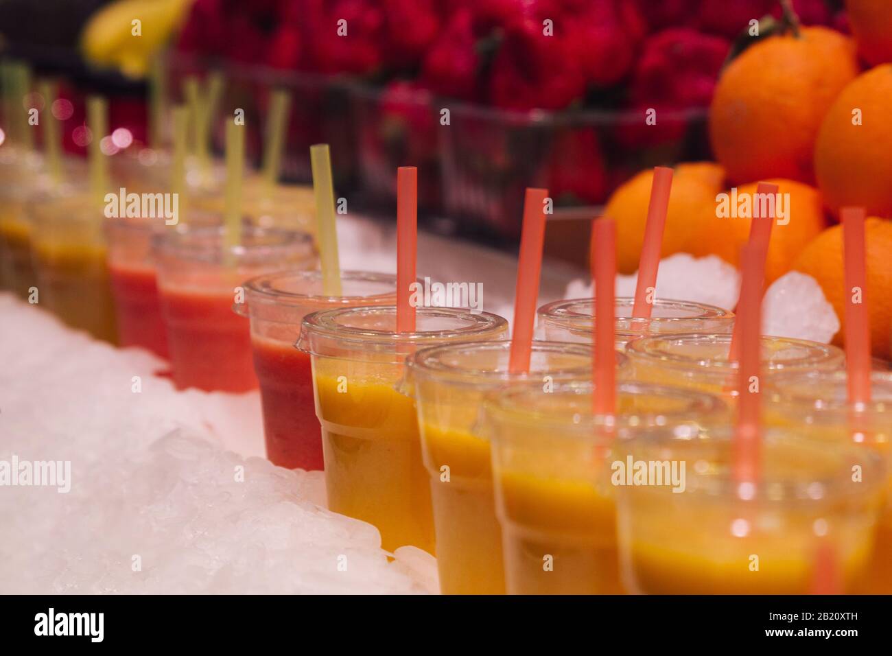 Foto di un gruppo di tazze di plastica con succhi di frutta freschi pronti per il consumo. Messa a fuoco selettiva Foto Stock