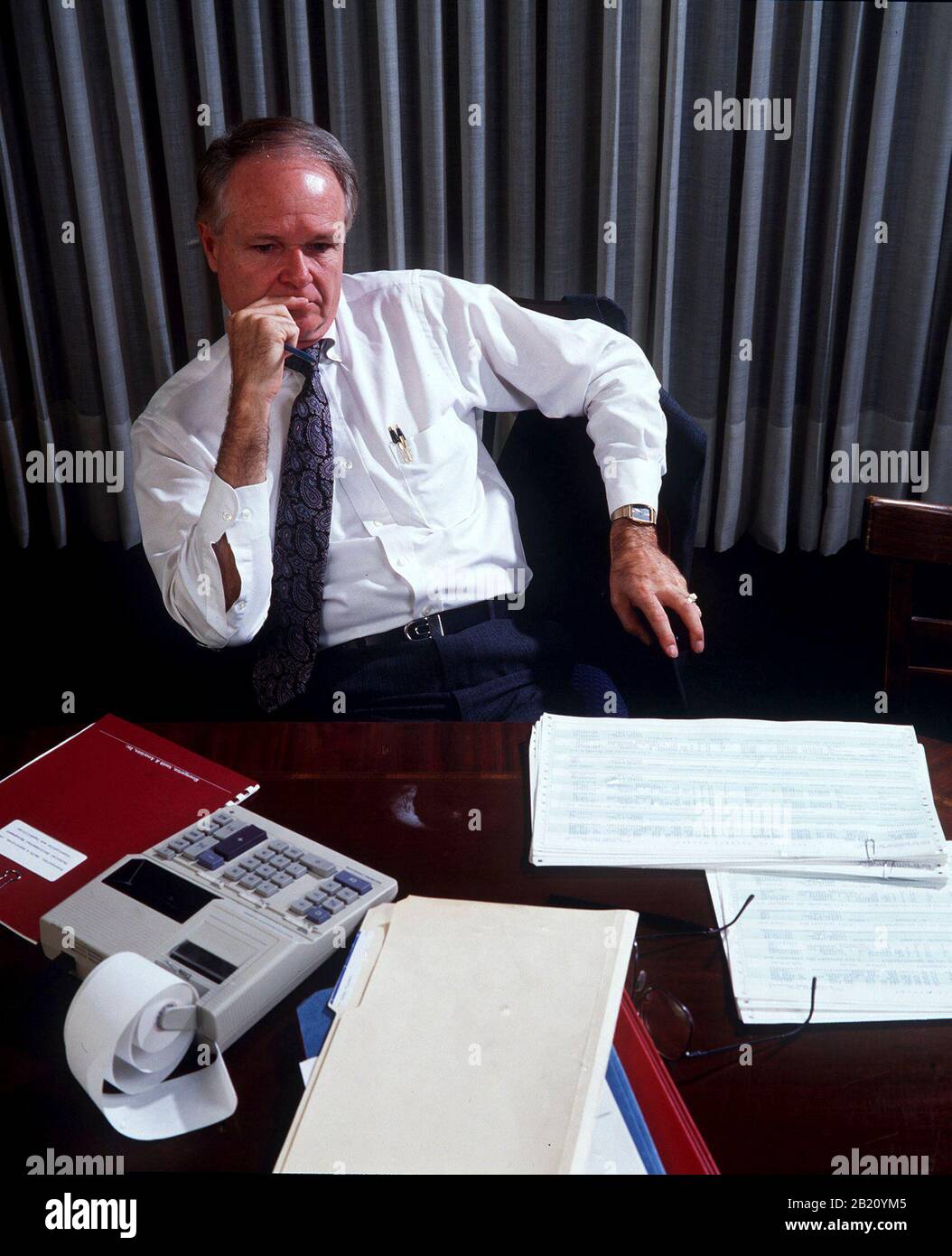 L'uomo d'affari nel suo ufficio prende una pausa dal lavoro sulla contabilità della sua azienda. ©Bob Daemmrich Foto Stock