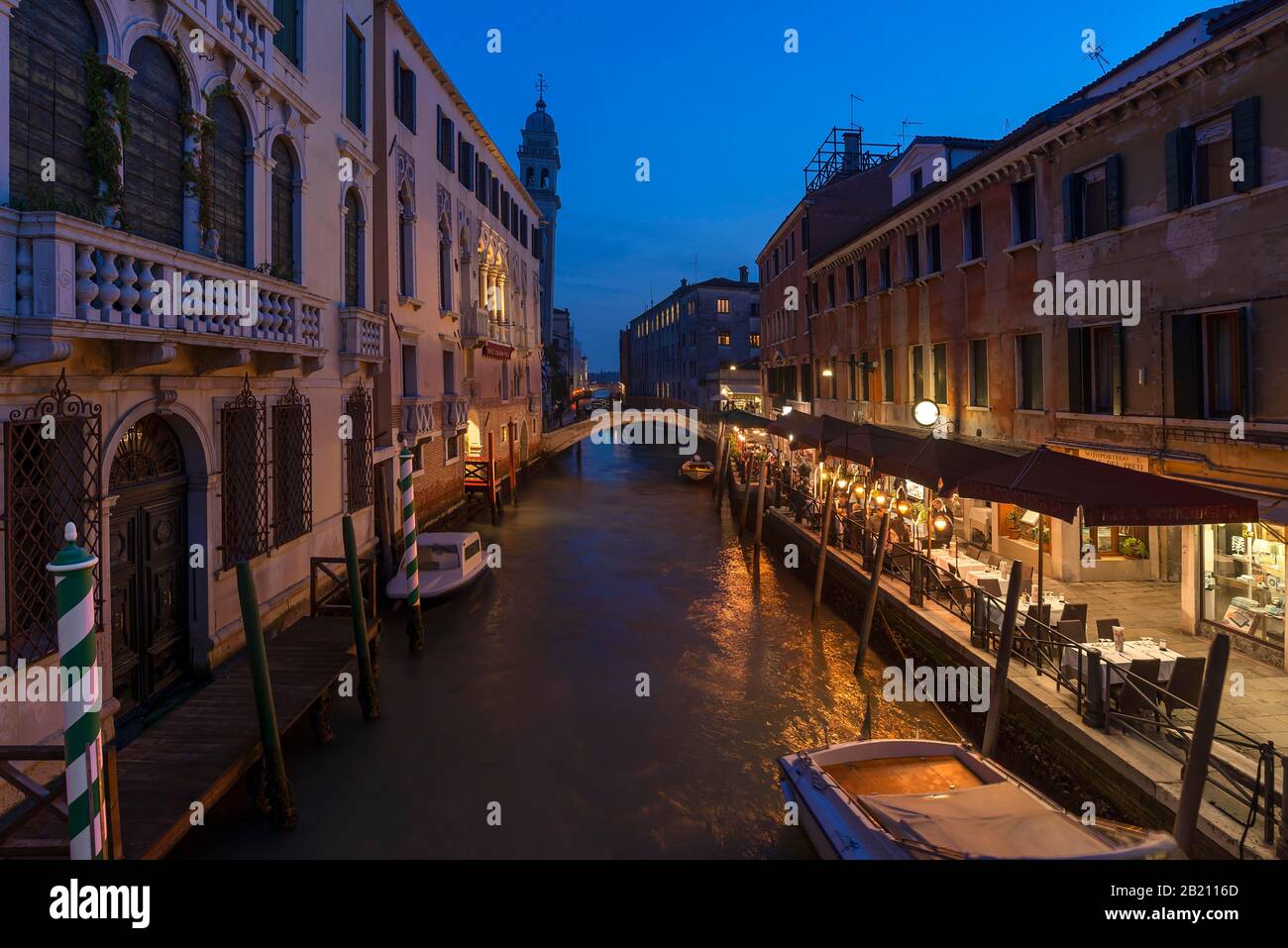 Atmosfera serale con ristorante sul canale, sul retro la torre della chiesa di Santa Maria della Pieta, Venezia, Veneto. Italia Foto Stock