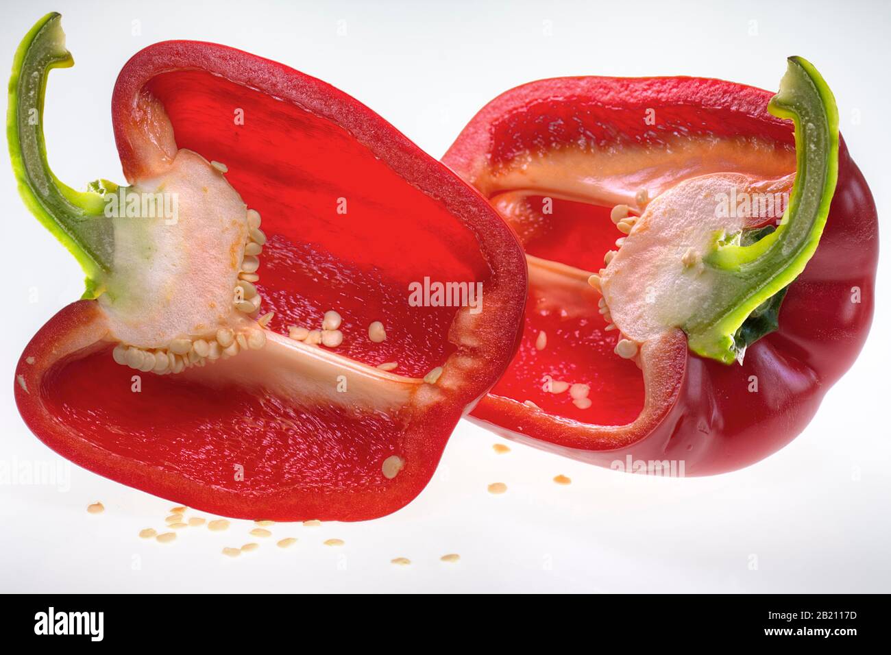 Peperone rosso dimezzato (Capsicum) su sfondo bianco, Germania Foto Stock