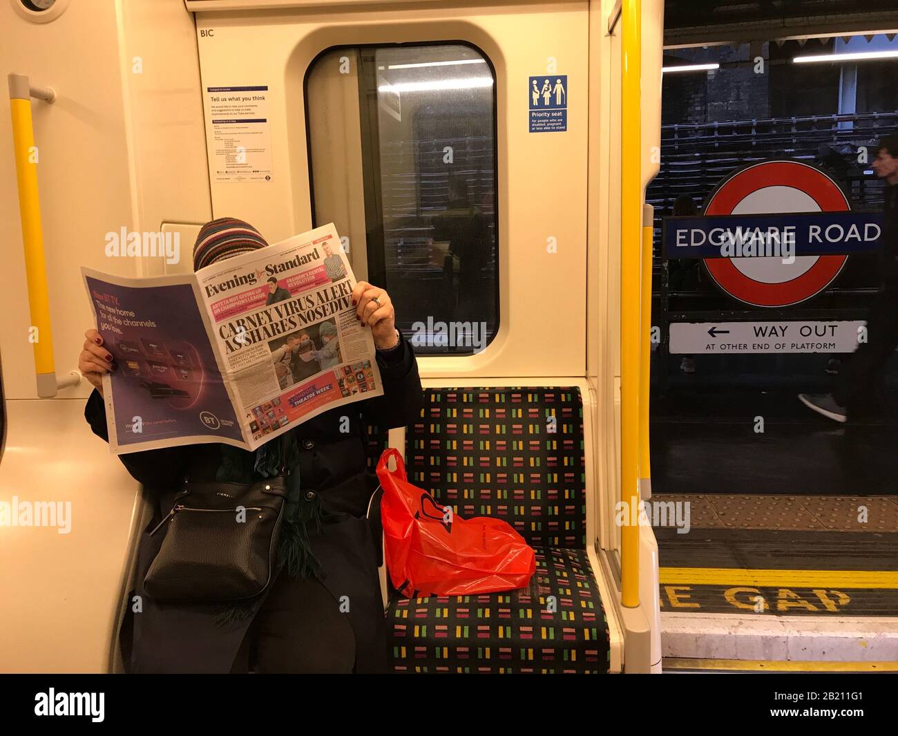 Londra, Regno Unito. 28th Feb 2020.Person su London Underground lettura Ultime notizie titoli di Coronavirus Credit: Credit: Matt Pennington / Alamy Live News Foto Stock