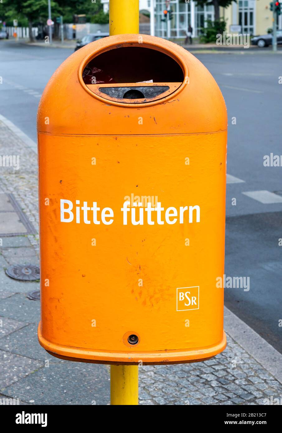 Buffo arancio spazzatura può con l'iscrizione Bitte fuetern, Berlino, Germania Foto Stock