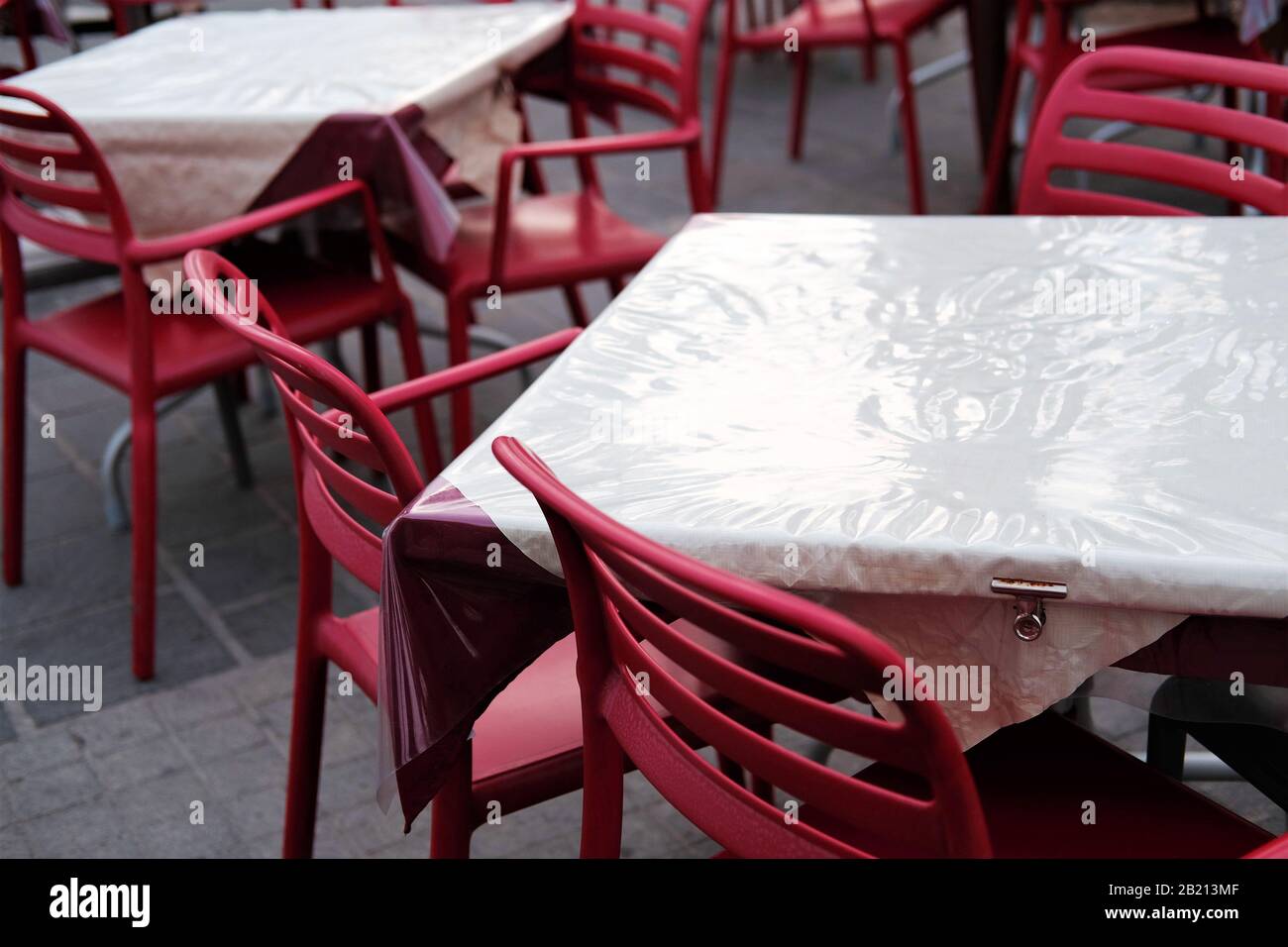 sedie e tavoli del ristorante vuoti in cattive condizioni atmosferiche in bassa stagione. Foto Stock