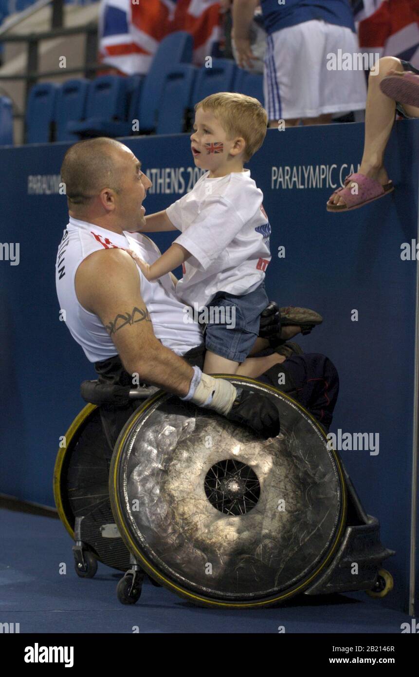 Atene, Grecia 19SEP04: Il rugby britannico celebra con il suo bambino dopo una vittoria straordinario nel rugby su sedia a rotelle. ©Bob Daemmrich Foto Stock