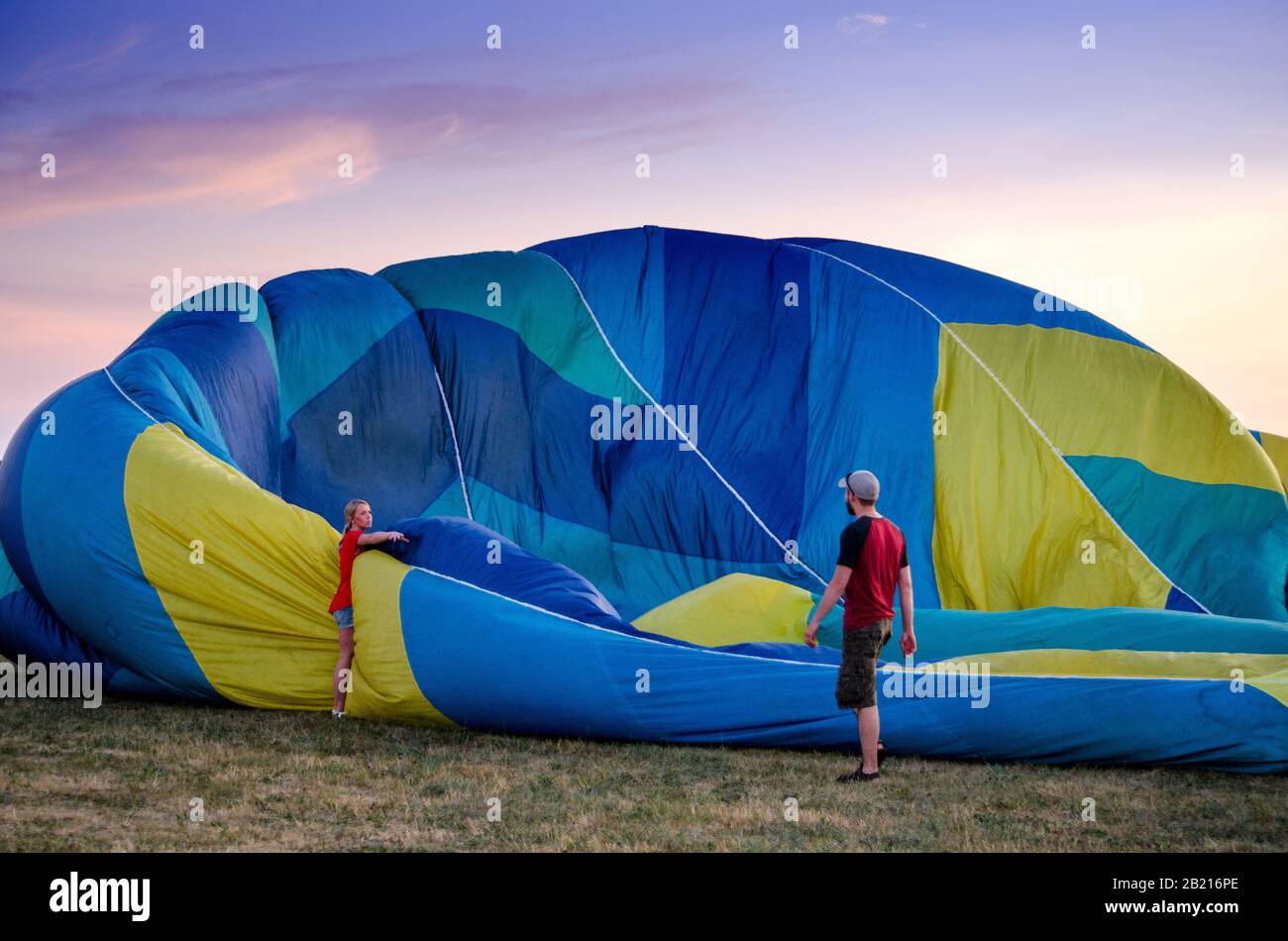 Battle Creek Michigan USA 3 luglio 2017; una coppia srotola una grande mongolfiera colorata, in uno spettacolo all'aperto Foto Stock