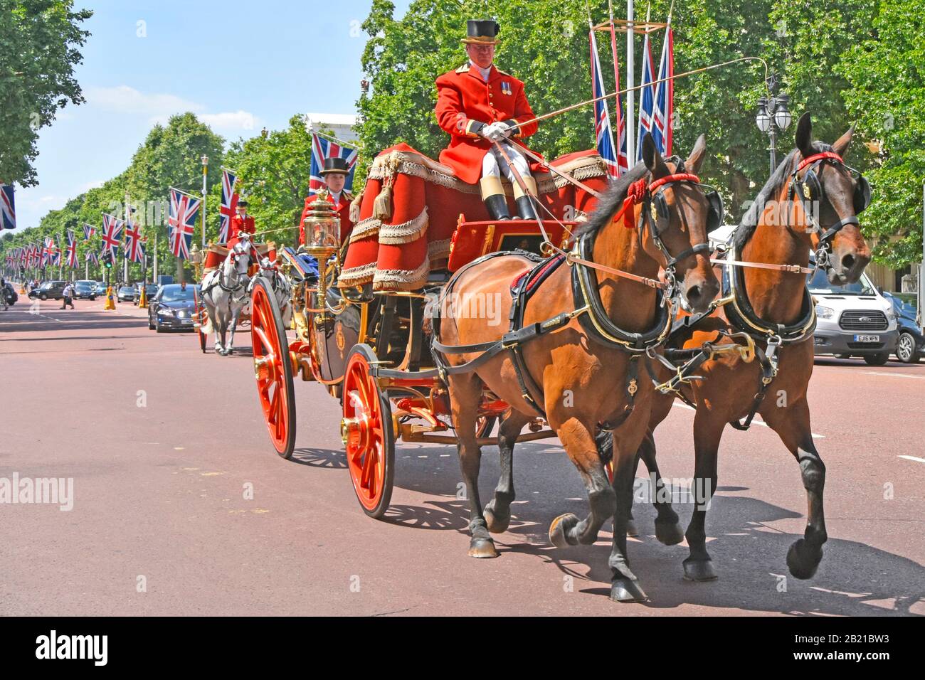 Primo piano due carrozze di Stato trainate da cavalli nel Mall Coachman & footman in uniforme trasporto dignitari diplomatici Unione bandiere Londra UK Foto Stock