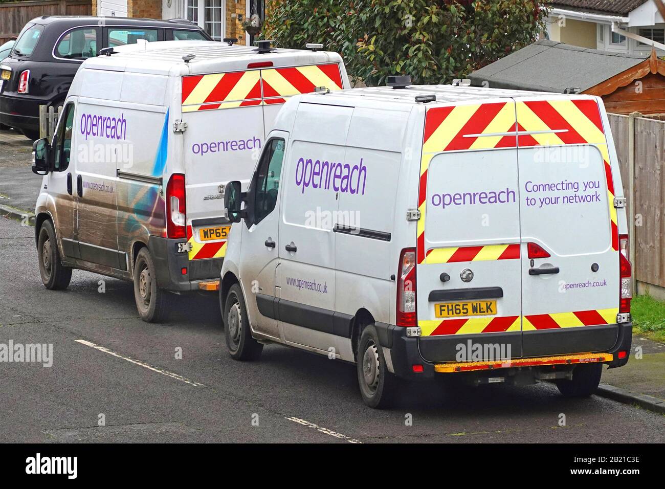 Vista laterale e posteriore di due furgoni sussidiari Openreach BT parcheggiati in strada residenziale fuori case che richiedono lavoro per il servizio a banda larga Essex Inghilterra Regno Unito Foto Stock