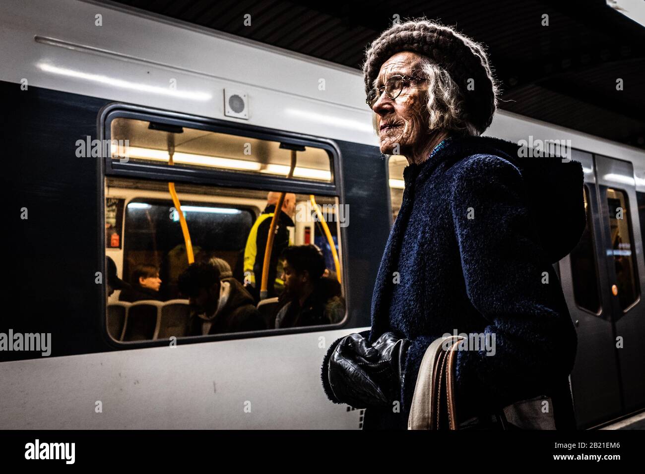 Vecchia signora in attesa del treno sotterraneo da sola. Foto Stock