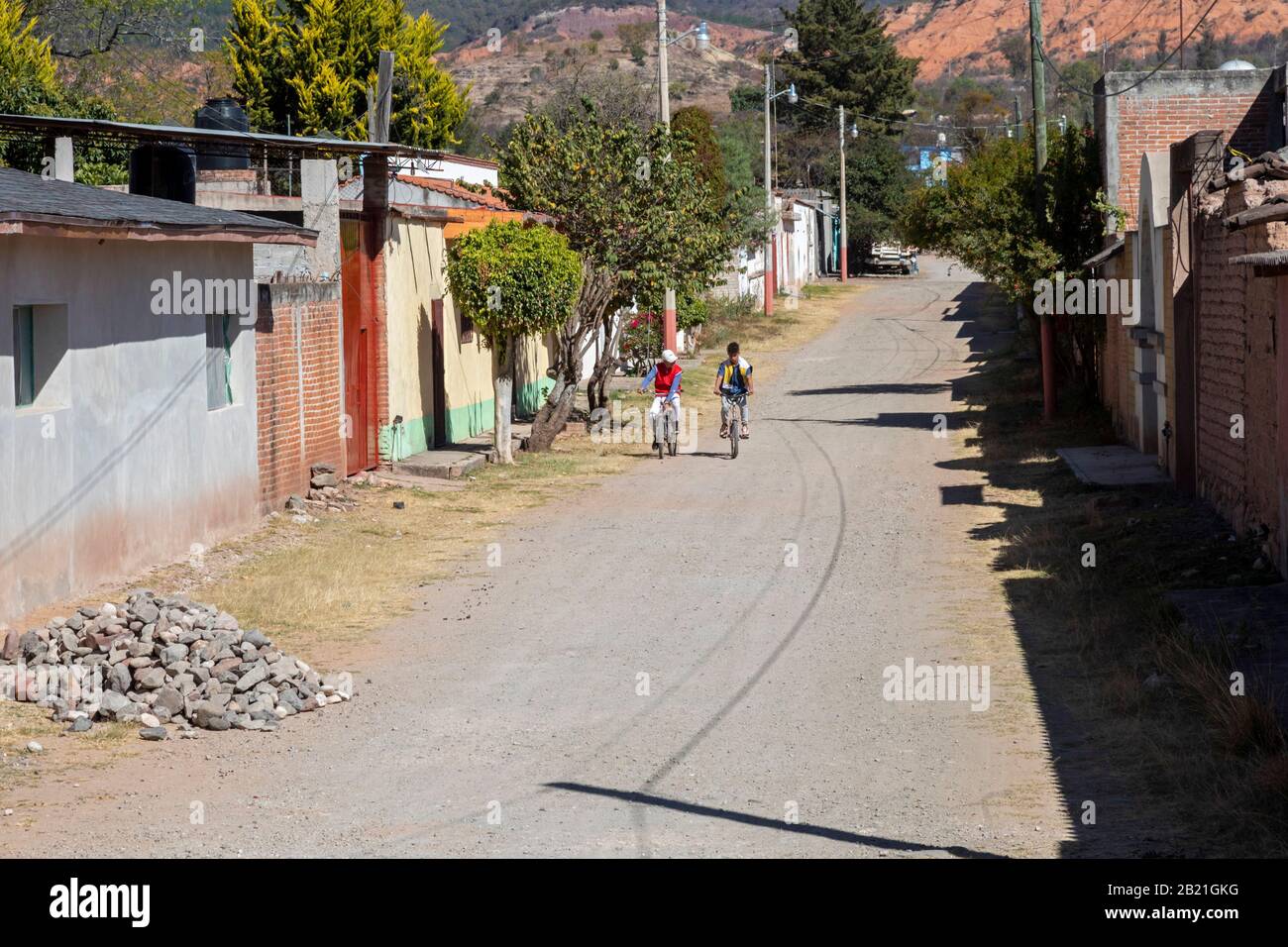 Yanhuitlan, Oaxaca, Messico - i ragazzi fanno un giro in bicicletta su una strada della città. Foto Stock