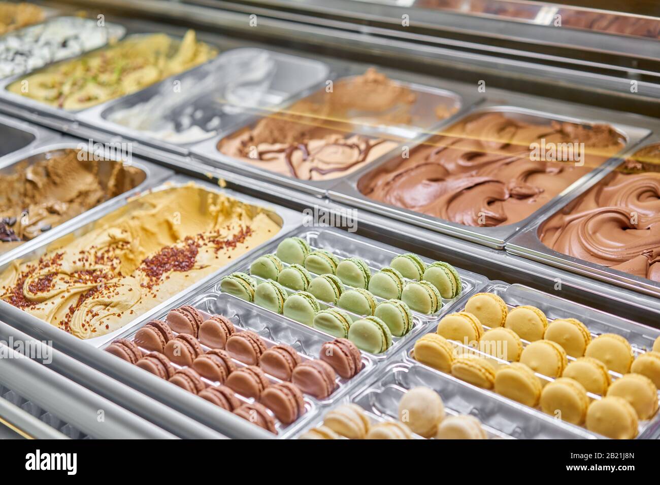 Assortimento di macaron colorati sulla vetrina dei caffè. Varietà di sapori macaron. Dolci di mandorle in negozio. Gelateria italiana. Foto Stock