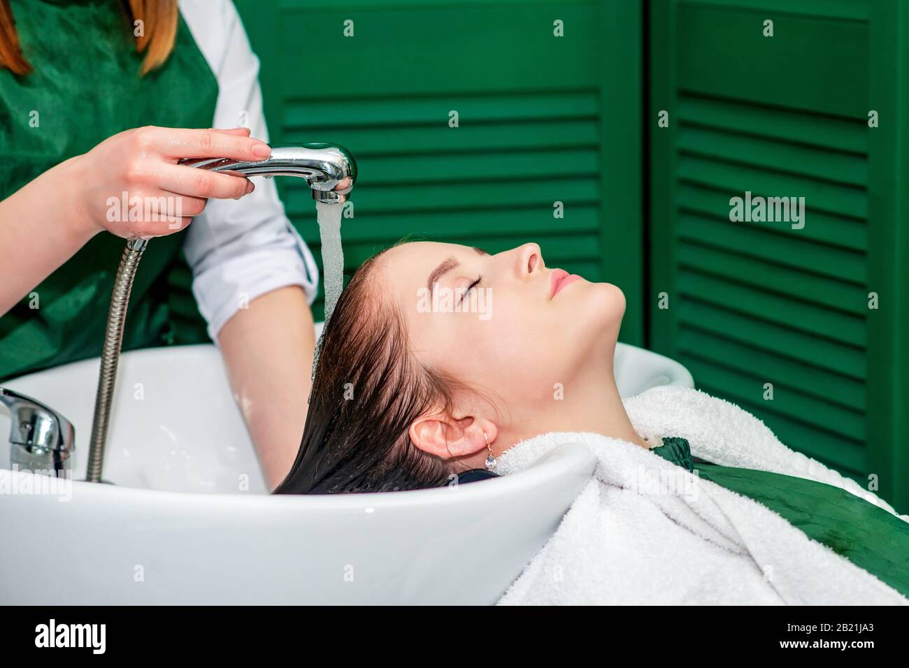 Parrucchiere lavaggio dei capelli della donna nel lavandino nel salone di bellezza. Foto Stock