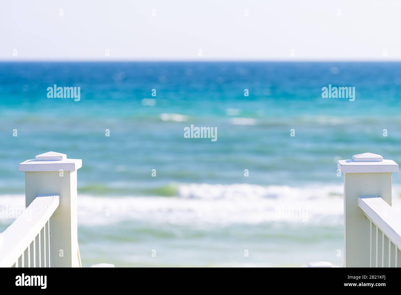 Lungomare, Florida bianca ringhiera scalinata in legno passerella giù vista dell'architettura sulla spiaggia oceano vista sfondo durante la giornata di sole e orizzonte Foto Stock