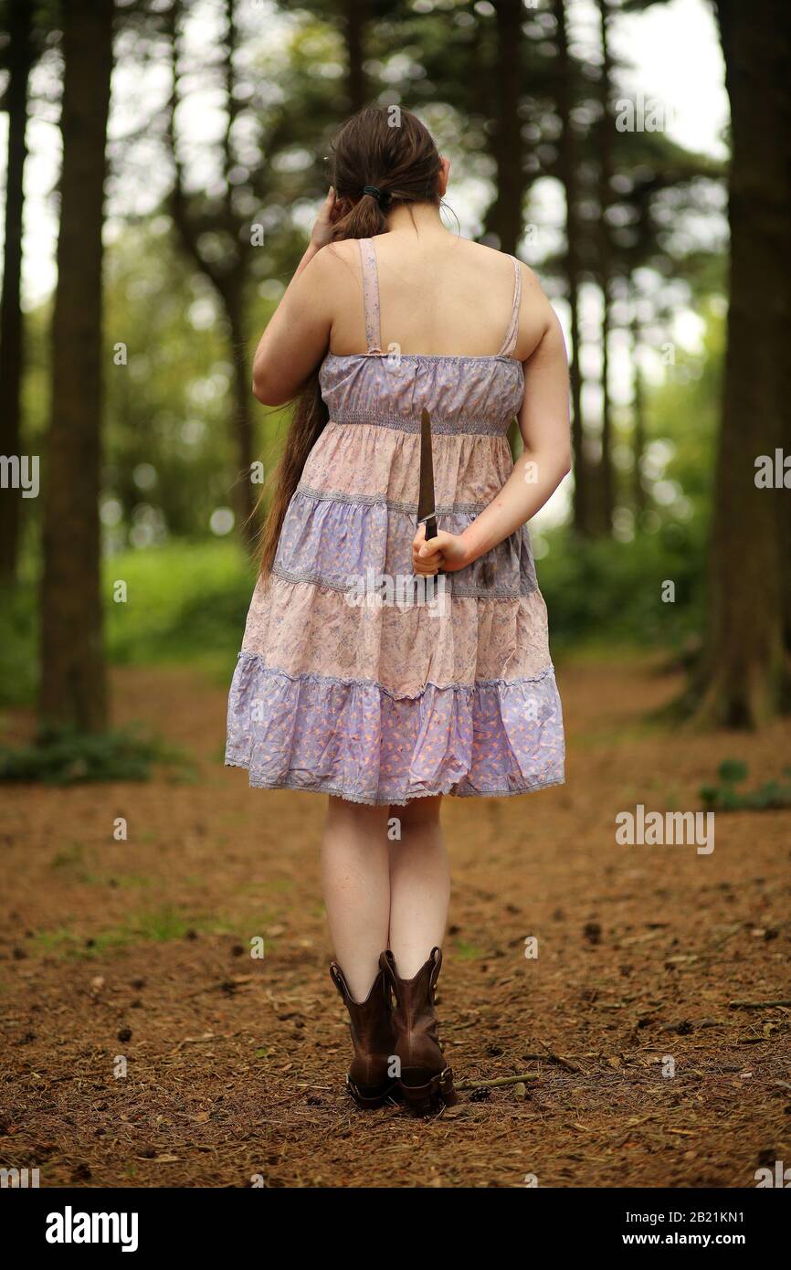 Luglio 2014 - giovane donna nei boschi, una ragazza perduta o guerriero con un grosso coltello vintage Foto Stock