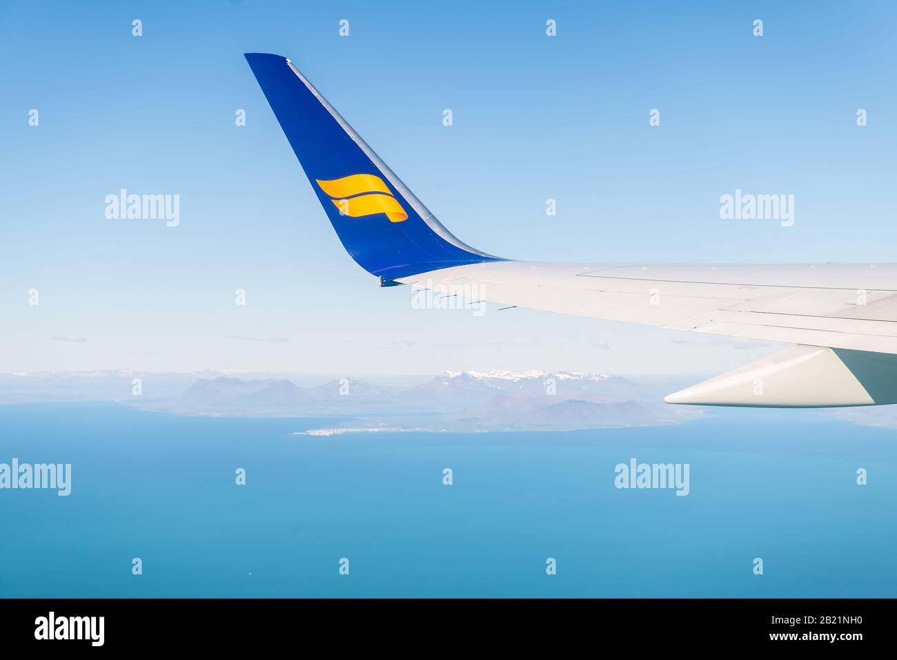 Keflavik, Islanda - 20 giugno 2018: Aereo Icelandair in cielo blu con vista dalla finestra vista ad angolo alto sull'oceano Atlantico artico e le montagne in h. Foto Stock