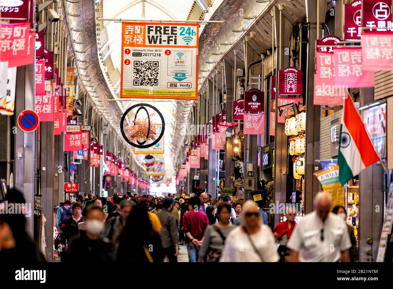 Kyoto, Giappone - 17 aprile 2019: Molte persone affollano turisti che camminano nei negozi del mercato Nishiki arcade con cartelli appesi Foto Stock