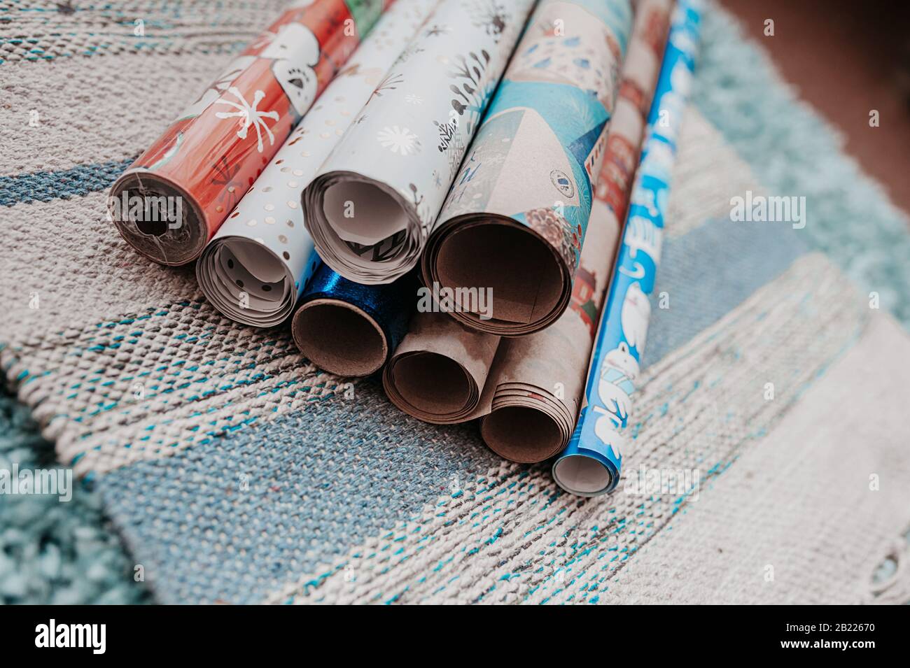 molti rotoli di carta da imballaggio colorata per presentson di natale un tovagliolo di cotone blu grigio Foto Stock