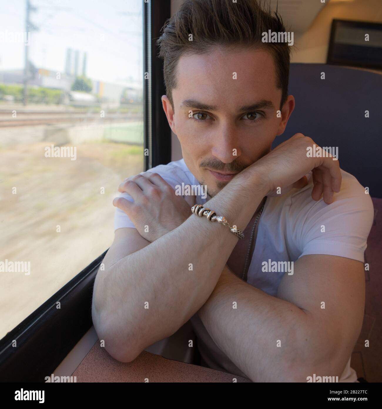 Giovane positivo bel uomo cavalcare un treno. Foto Stock