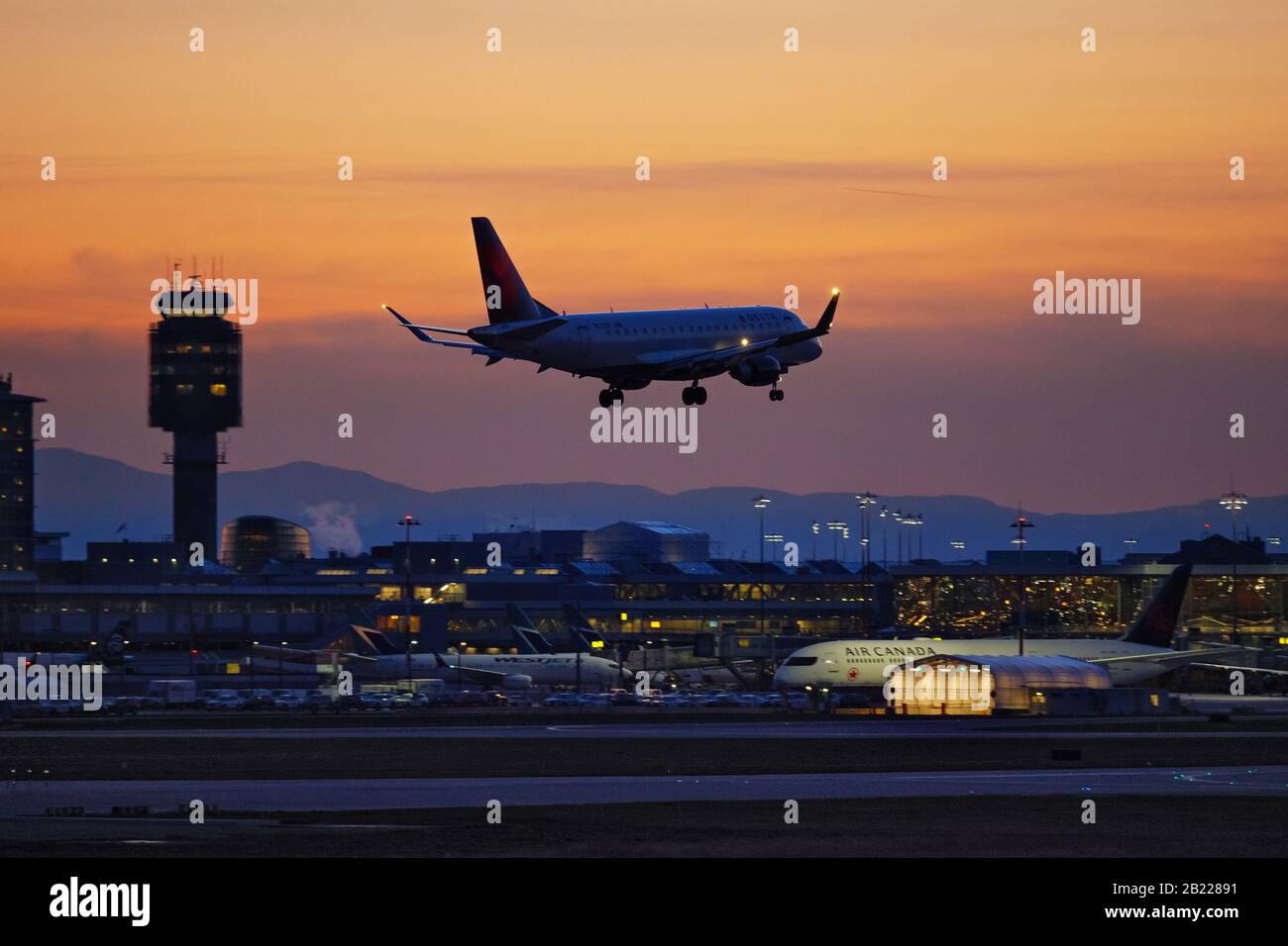 Richmond, British Columbia, Canada. 19th Feb, 2020. Un jet regionale Delta Connection Embraer E175LR (N272SY), di proprietà e gestito da SkyWest Airlines, atterra al tramonto, all'aeroporto internazionale di Vancouver. Credito: Bayne Stanley/Zuma Wire/Alamy Live News Foto Stock
