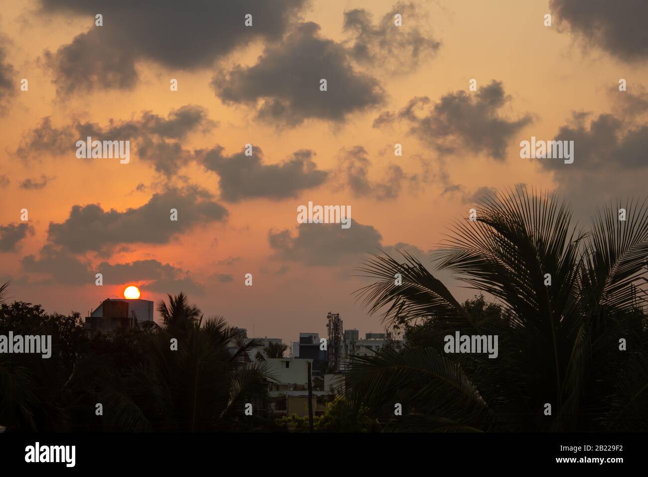 Vista panoramica del cielo con nuvole scure durante il tramonto in città Foto Stock