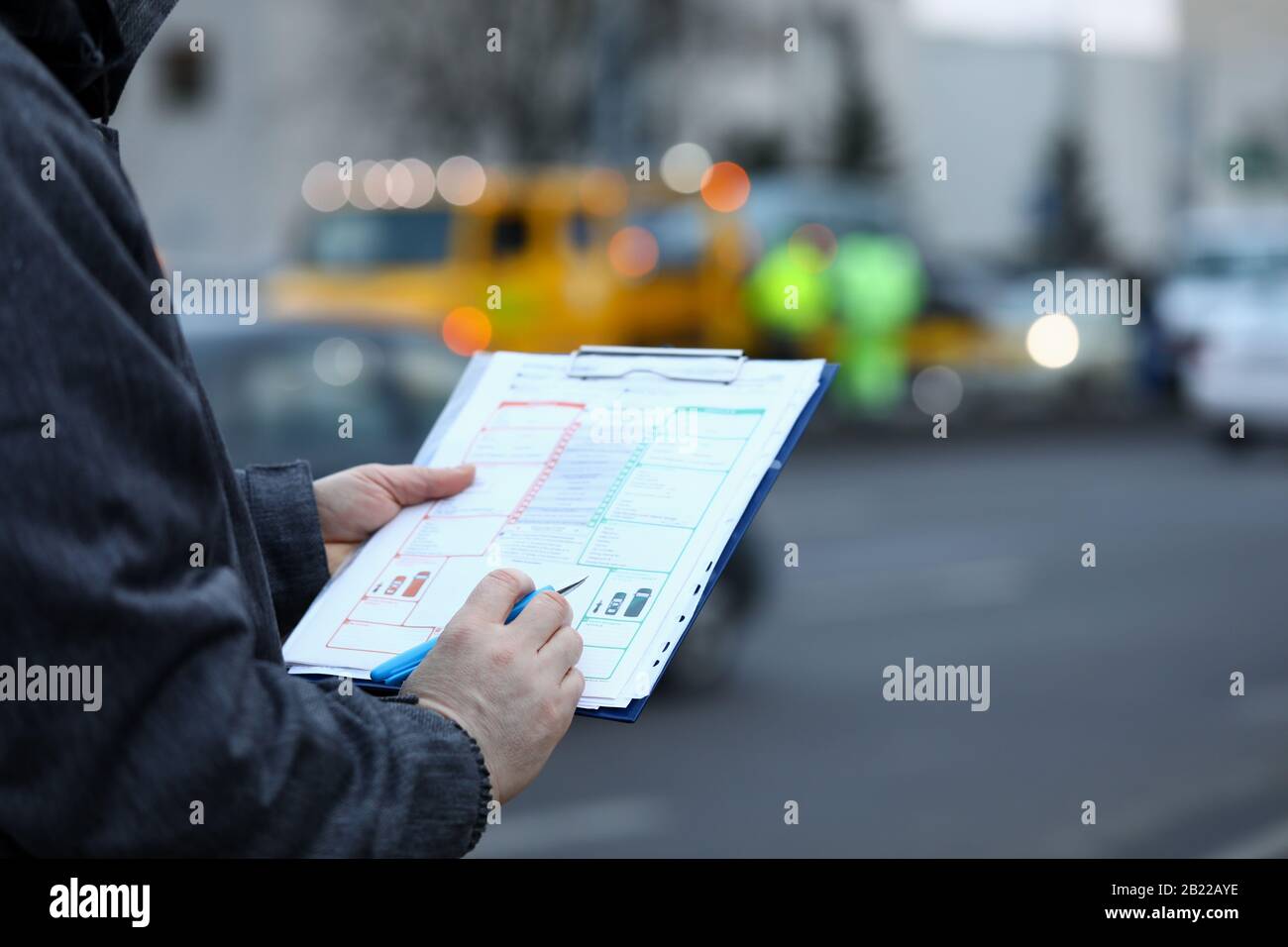 L'uomo compila il modulo di assicurazione sul veicolo di movimento Foto Stock