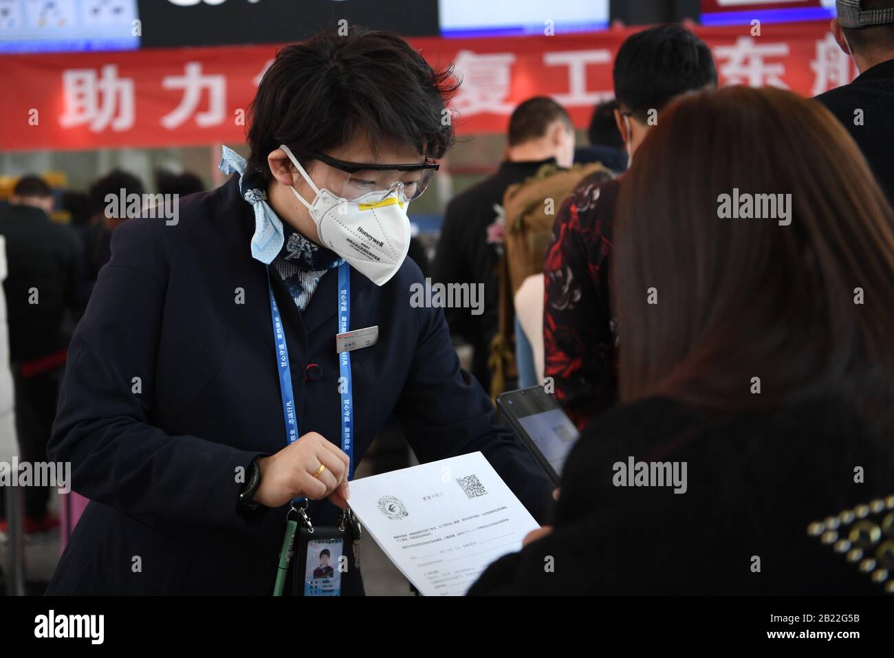 Lanzhou, La Provincia Cinese Di Gansu. 29th Feb, 2020. Un membro dello staff di China Eastern Airlines guida i lavoratori migranti a registrare le loro condizioni di salute tramite cellulare all'aeroporto internazionale di Zhongchuan a Lanzhou, nella provincia di Gansu nella Cina nord-occidentale, 29 febbraio 2020. Un volo charter della China Eastern Airlines ha portato 117 lavoratori migranti da Lanzhou a riprendere il lavoro nella città di Nanchang, nella provincia di Jiangxi nella Cina orientale. Credit: Fan Peishen/Xinhua/Alamy Live News Foto Stock