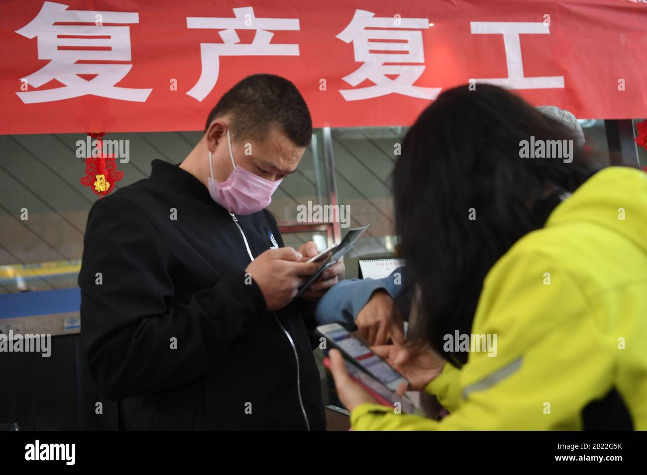 Lanzhou, La Provincia Cinese Di Gansu. 29th Feb, 2020. I lavoratori migranti registrano le loro condizioni di salute via cellulare prima di salire a bordo all'aeroporto internazionale di Zhongchuan a Lanzhou, nella provincia di Gansu nella Cina nord-occidentale, 29 febbraio 2020. Un volo charter della China Eastern Airlines ha portato 117 lavoratori migranti da Lanzhou a riprendere il lavoro nella città di Nanchang, nella provincia di Jiangxi nella Cina orientale. Credit: Fan Peishen/Xinhua/Alamy Live News Foto Stock