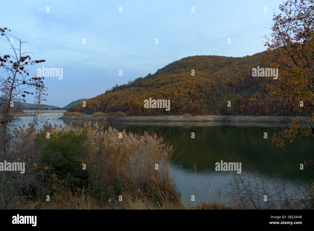 Il lago artificiale Metalliou in una cornice di alberi e piante. Foto Stock